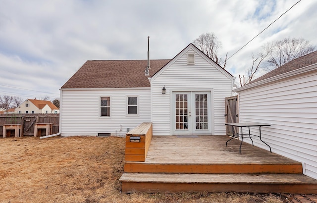 back of property with a wooden deck, fence, roof with shingles, and french doors