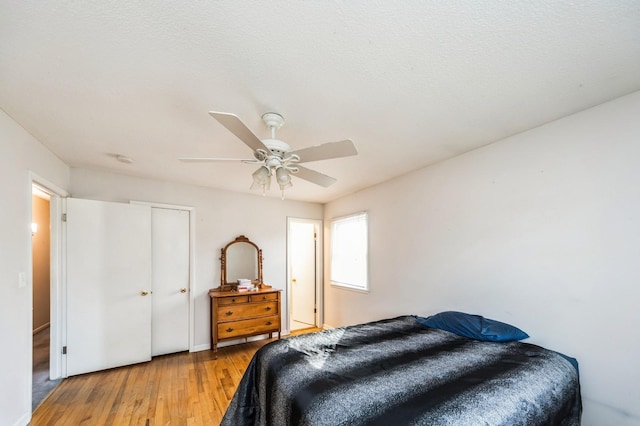 bedroom with ceiling fan, a closet, and wood finished floors