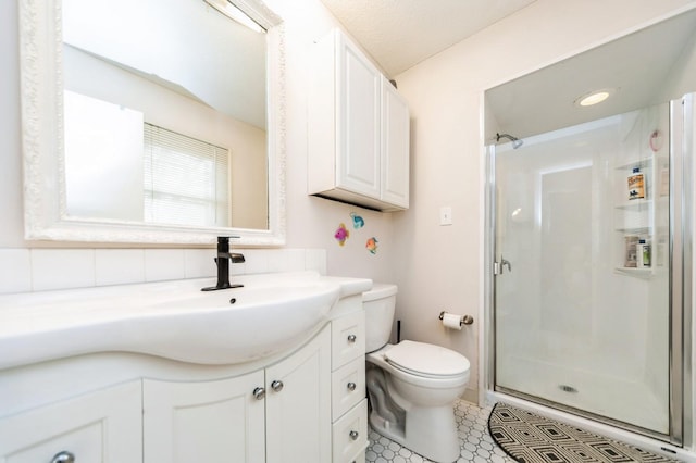 bathroom featuring toilet, a shower stall, vanity, and decorative backsplash