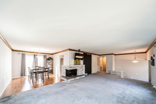 unfurnished living room featuring a fireplace, baseboards, crown molding, and carpet flooring