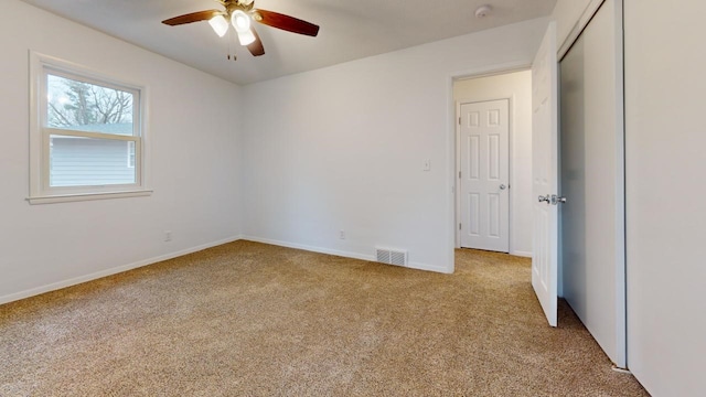 unfurnished bedroom with a ceiling fan, carpet, visible vents, baseboards, and a closet