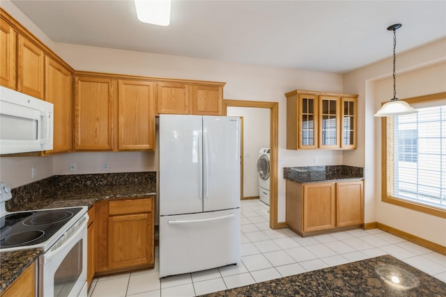 kitchen with white appliances, washer / dryer, hanging light fixtures, brown cabinetry, and glass insert cabinets