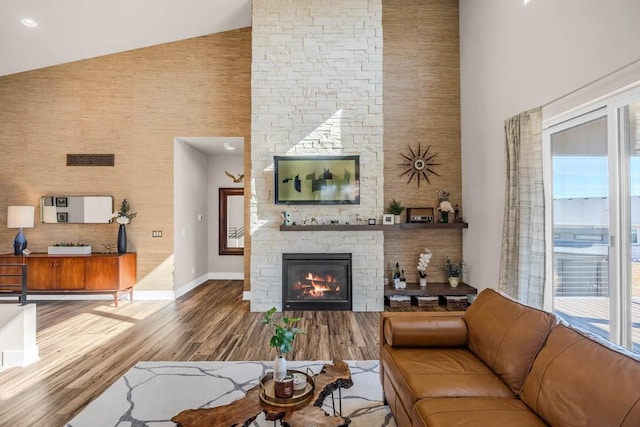 living room with a fireplace, baseboards, a wealth of natural light, and wood finished floors