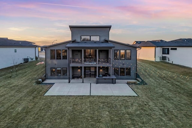 back of property with a yard, a patio, and central AC unit