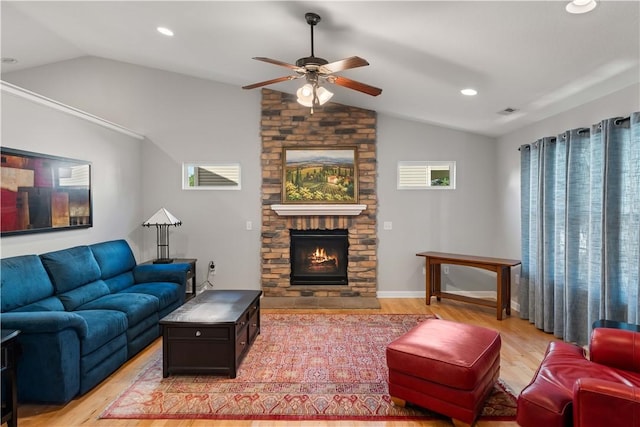 living room featuring lofted ceiling, a fireplace, light wood-style flooring, and a healthy amount of sunlight