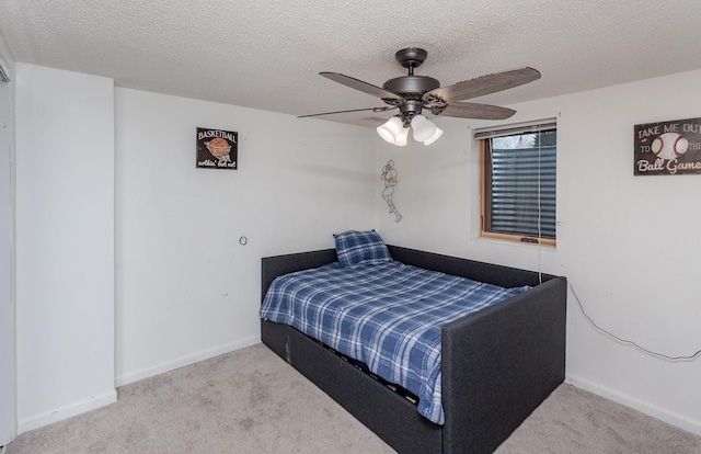 carpeted bedroom with a ceiling fan, a textured ceiling, and baseboards