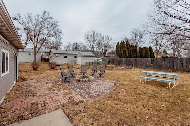 view of yard with an outdoor fire pit, a fenced backyard, and a patio