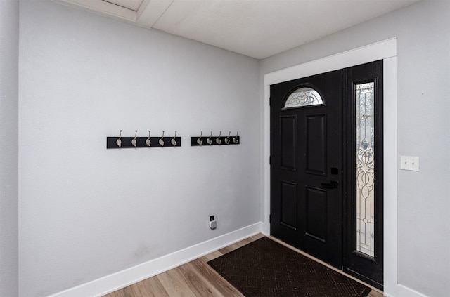 entryway featuring baseboards and wood finished floors