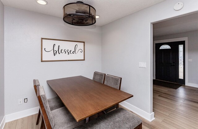 dining area featuring baseboards, wood finished floors, and recessed lighting