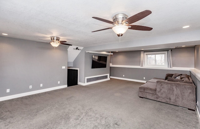 unfurnished living room with a textured ceiling, ceiling fan, carpet, and baseboards