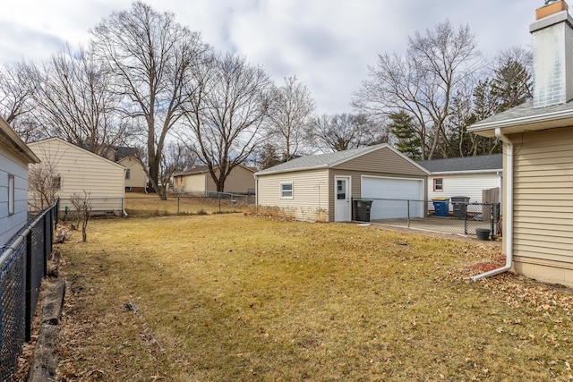 view of yard featuring an outbuilding, fence, and a garage