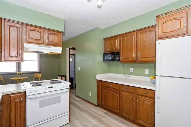 kitchen with light countertops, white appliances, brown cabinets, and under cabinet range hood