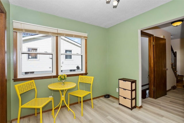 interior space featuring wood finished floors, a textured ceiling, baseboards, and stairs