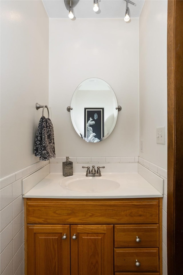 bathroom with wainscoting, vanity, and tile walls