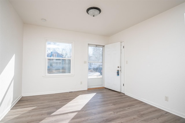 spare room with light wood finished floors and baseboards