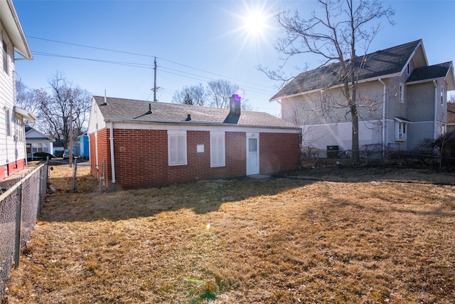 exterior space featuring a yard, fence, and brick siding