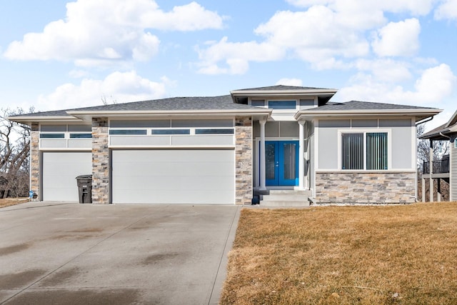 prairie-style house featuring a garage, stone siding, french doors, and concrete driveway