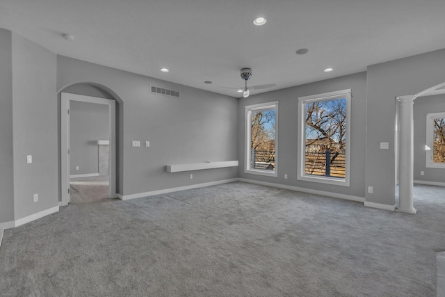 unfurnished room featuring arched walkways, recessed lighting, visible vents, carpet flooring, and ornate columns