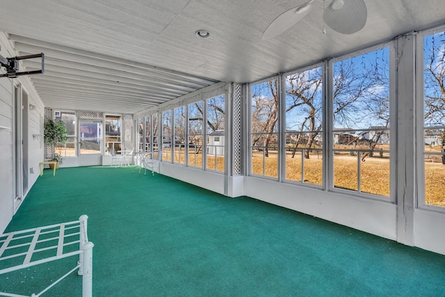 unfurnished sunroom with ceiling fan