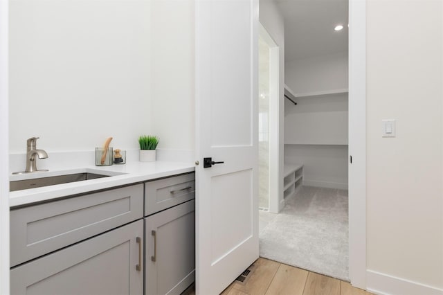 bathroom with recessed lighting, wood finished floors, and vanity