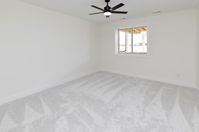 spare room with ceiling fan, carpet, visible vents, and baseboards