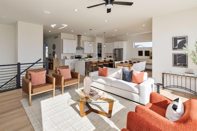 living area with light wood-style flooring, visible vents, ceiling fan, and recessed lighting