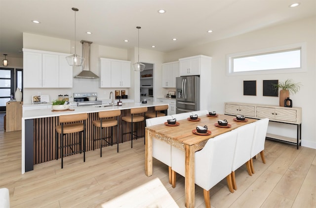 dining room with light wood-type flooring and recessed lighting