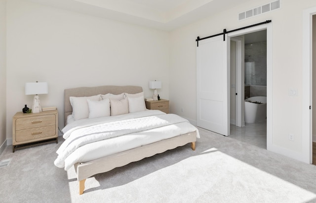 bedroom with carpet, visible vents, baseboards, and a barn door