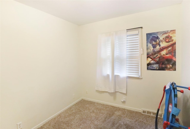 empty room featuring carpet, visible vents, and baseboards