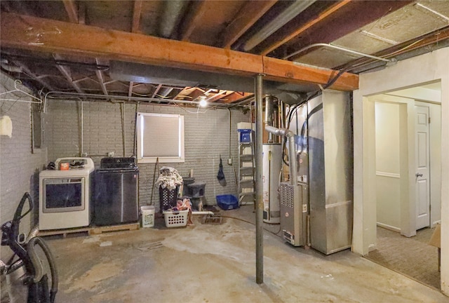 unfinished basement featuring heating unit, brick wall, washing machine and dryer, and gas water heater