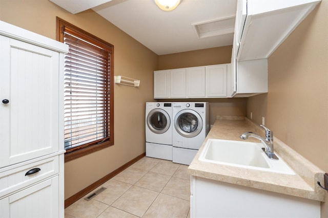 clothes washing area featuring cabinet space, visible vents, washer and dryer, a sink, and light tile patterned flooring