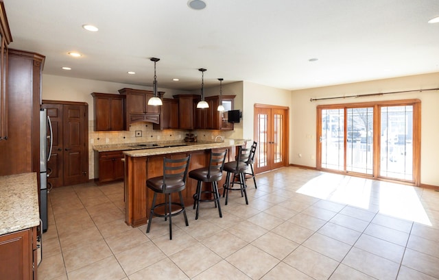 kitchen featuring light tile patterned floors, a kitchen bar, decorative backsplash, and french doors