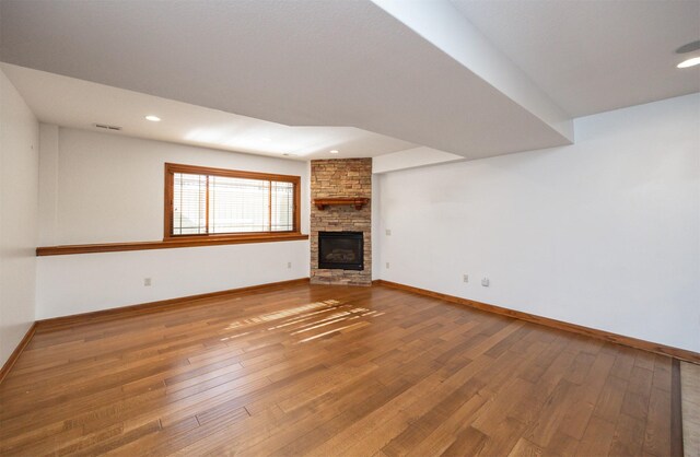 1205 NE 31st St, Ankeny, IA 50021 - unfurnished living room featuring hardwood / wood-style flooring, recessed lighting, and a stone fireplace
