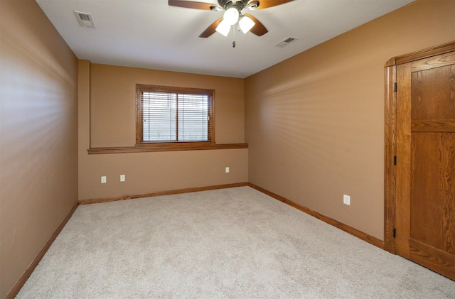 spare room featuring carpet, visible vents, ceiling fan, and baseboards