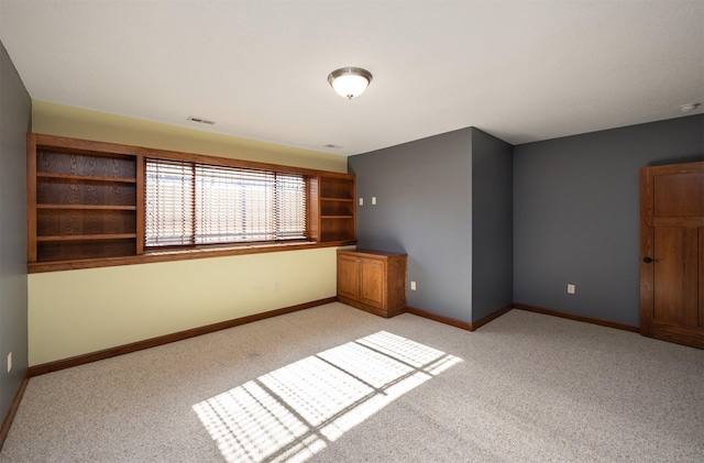 spare room with light carpet, visible vents, and baseboards