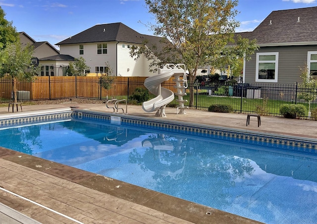 view of swimming pool with a fenced in pool, fence, and a water slide