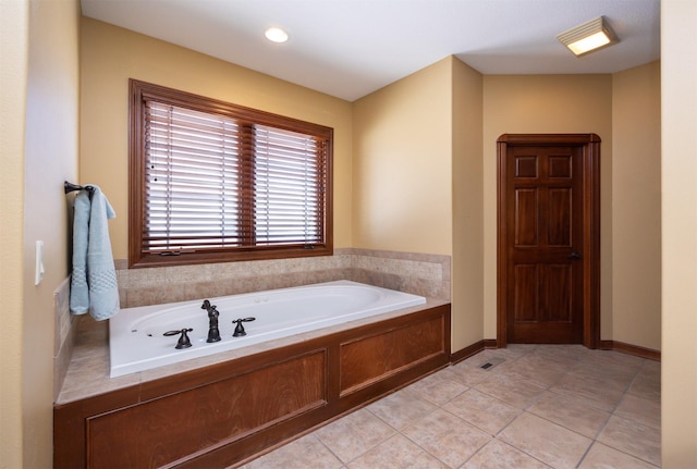 full bathroom featuring tile patterned flooring, baseboards, and a bath