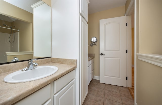 full bathroom with a shower, vanity, baseboards, and tile patterned floors