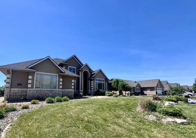 1205 NE 31st St, Ankeny, IA 50021 - view of front facade featuring stucco siding, stone siding, and a front lawn