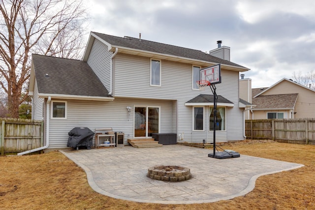 rear view of property with a fire pit, a patio, a fenced backyard, and a chimney