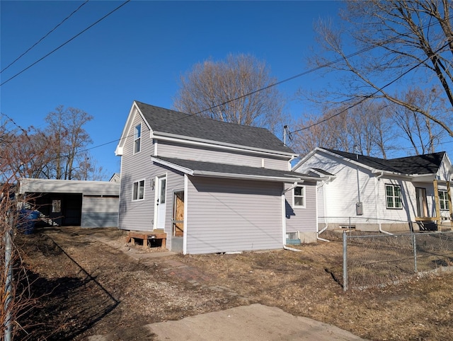 view of property exterior featuring a shingled roof and fence