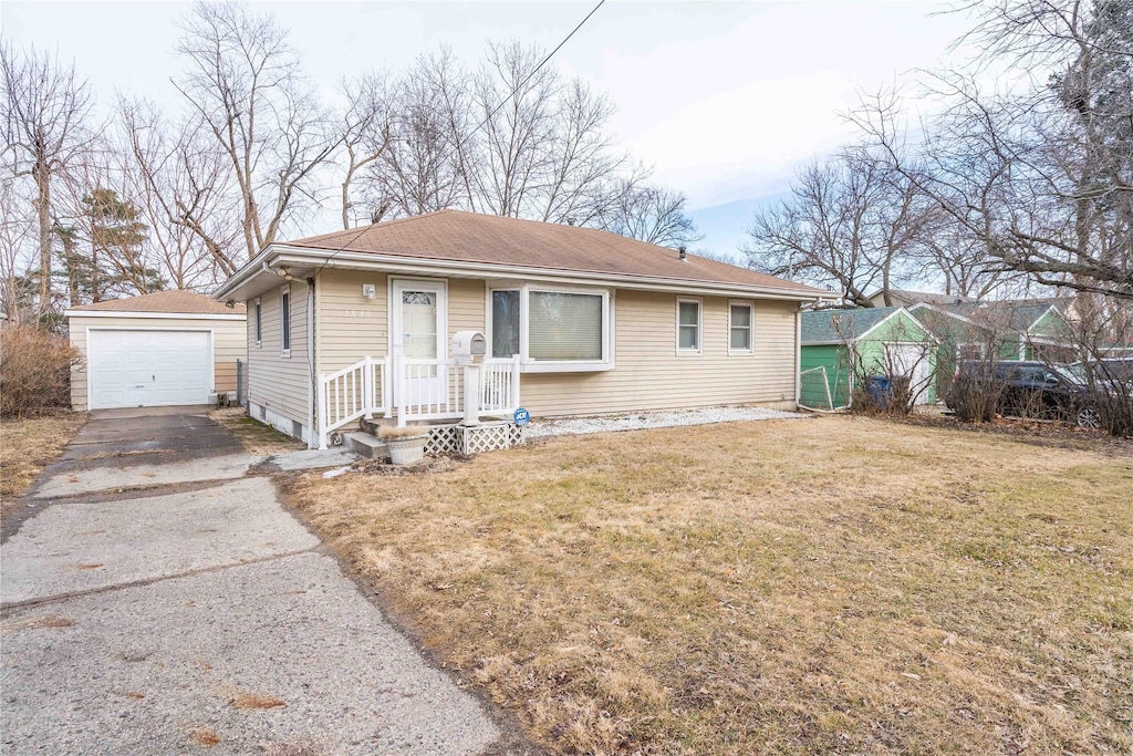 3839 34th St, Des Moines, IA 50310 - bungalow-style home with a garage, an outdoor structure, driveway, and a front lawn