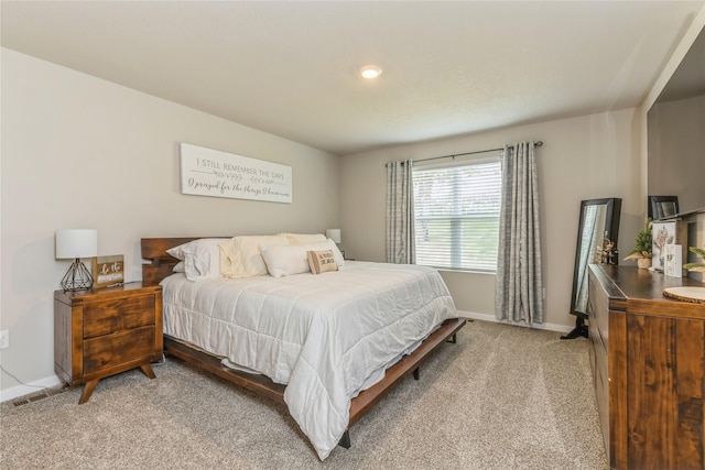 bedroom with light carpet and baseboards