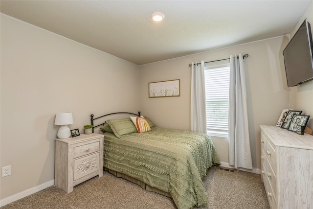 bedroom with light carpet, visible vents, and baseboards