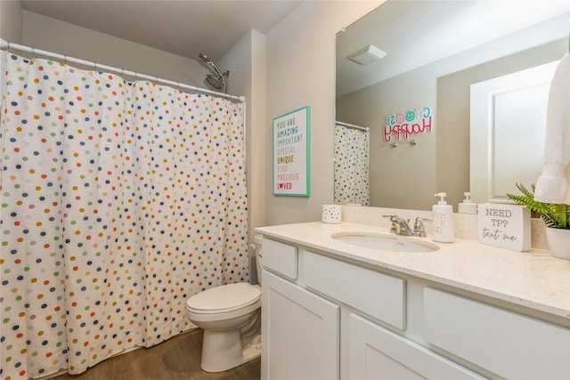 full bath featuring visible vents, a shower with shower curtain, toilet, vanity, and wood finished floors