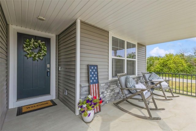 property entrance featuring covered porch and stone siding