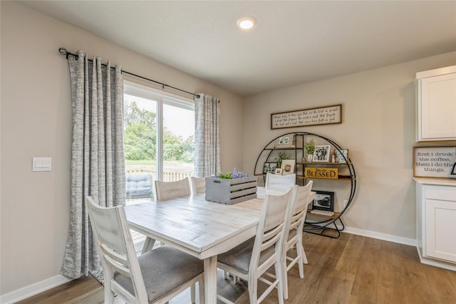 dining space with baseboards and wood finished floors