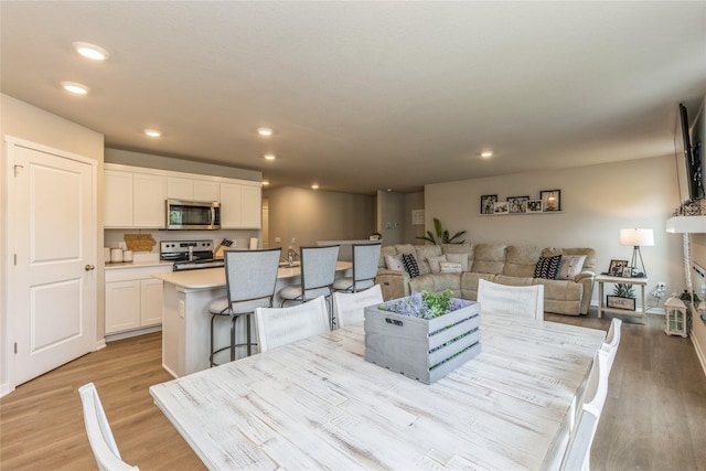 dining space with recessed lighting and light wood-style flooring