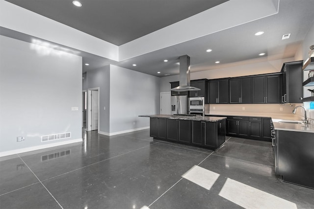 kitchen featuring island range hood, stainless steel appliances, a sink, visible vents, and dark cabinetry