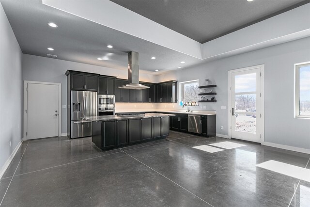 kitchen featuring baseboards, a kitchen island, island exhaust hood, stainless steel appliances, and dark cabinetry